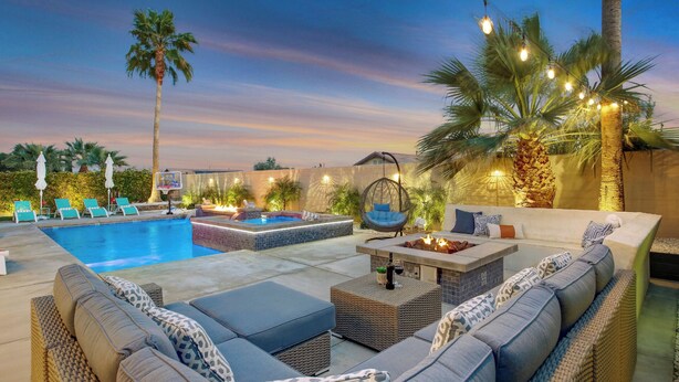 A pool area with lounge chairs, a hot tub, and a seating area with cushions and a hanging chair. - Coachella Escape. Brand New Luxury home in gated community. (Indio)