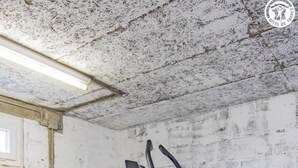 Un vélo d’appartement dans une pièce dont le sol est en béton et les murs sont blancs.