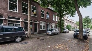 A row of brick townhouses with parked cars on a cobblestone street. - Enjoy your stay in a cosy corner in Rotterdam (Rotterdam)