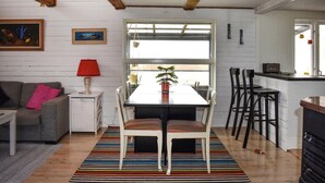 A cozy living room with a dining table, chairs, a colorful striped rug, a sofa, a lamp, and a window with a view. - 3 bedroom nice home in Sölvesborg (Sölvesborg)