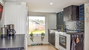 A modern kitchen with a large window, stainless steel appliances, and a tiled backsplash. - 3 bedroom nice home in Sölvesborg (Sölvesborg)