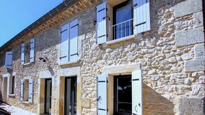 A stone building with multiple windows and doors, featuring a traditional architectural style. - Nice home in La Garde Adhémar (La Garde Adhémar)
