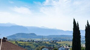 A rural landscape with mountains, houses, and tall cypress trees. - Studio Apartment 'Peter Paul  Penegal' with Mountain View and Shared Terrace (Eppan an der Weinstrasse)