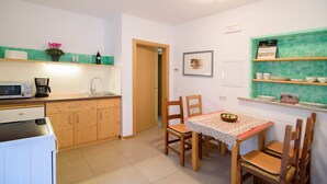 A compact kitchen with a microwave, coffee maker, and wooden cabinets.