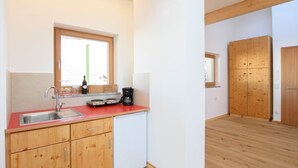 A compact kitchen with wooden cabinets, a sink, and a coffee maker.