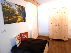 Une chambre à coucher comprenant un lit, une armoire, un tableau accroché au mur et une prise de courant.