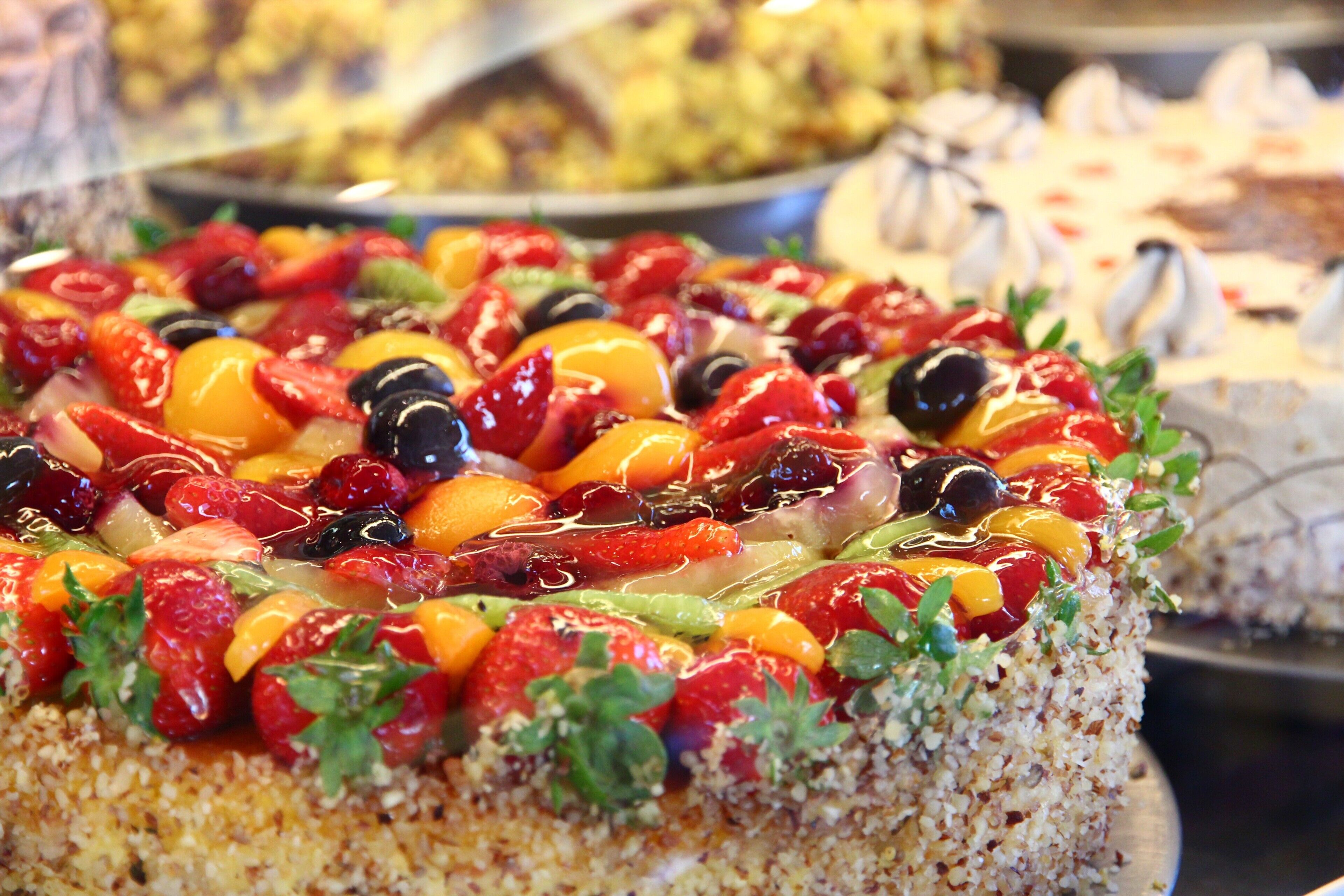 Un gâteau décoré de différents fruits.