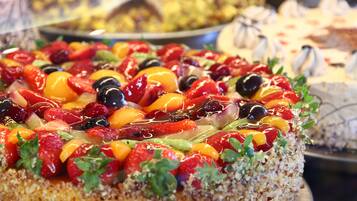Un gâteau décoré de différents fruits.