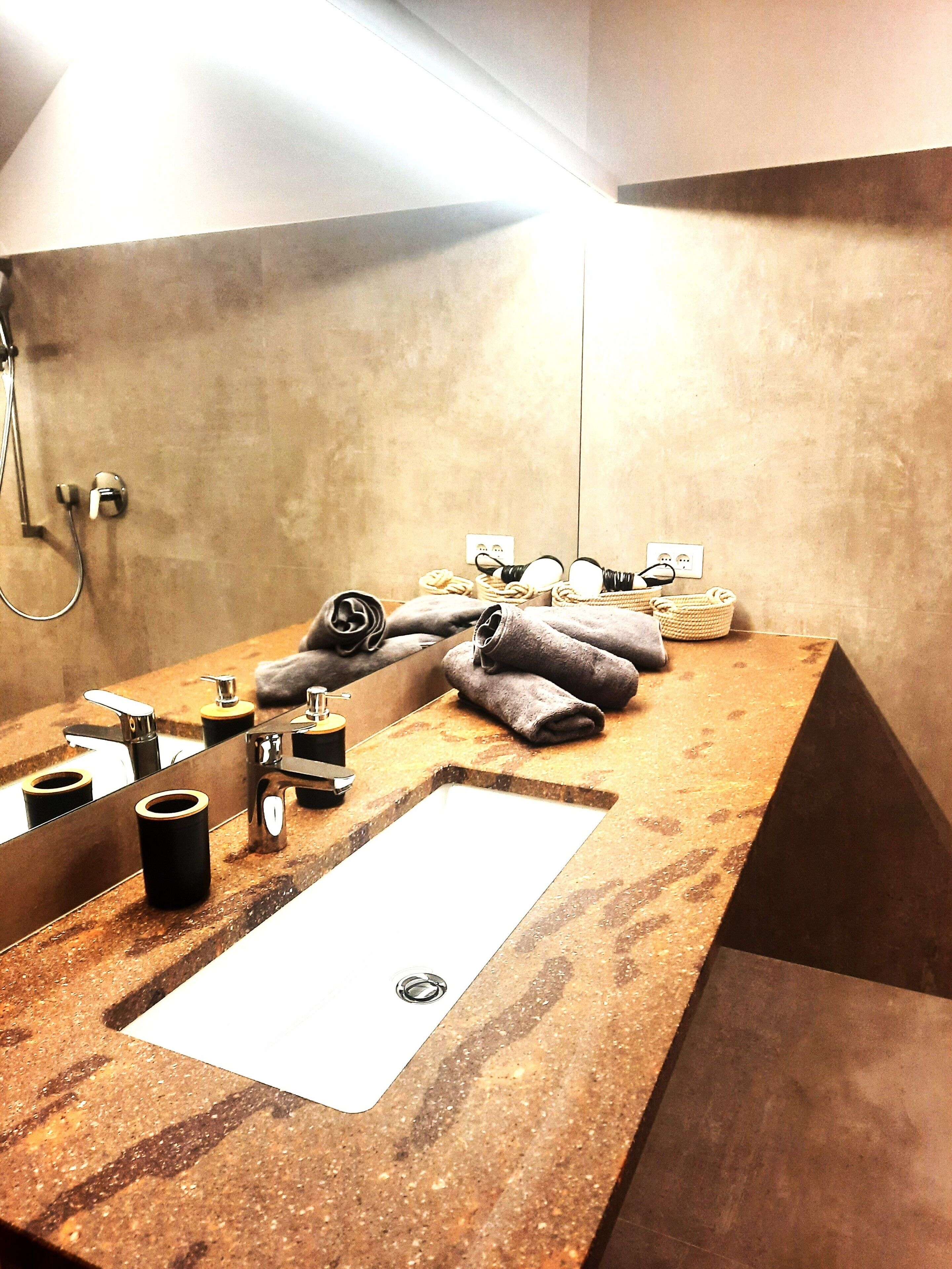 A bathroom with a marble sink, towel rack, and a shower area.