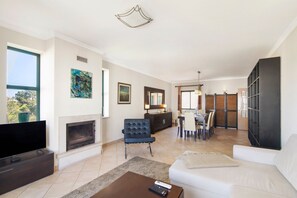 Un salon moderne avec une cheminée, un coin repas et une grande fenêtre.