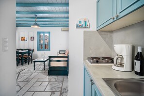 A kitchen with a coffee maker, a sink, and a bottle of wine.