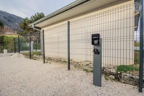 Secure gated entrance with a wallbox for convenient charging.