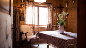 A wooden interior with a table, chair, and a vase of flowers. - Chalet 'Am Reschensee' with Lake View, Private Terrace and Private Garden (Resia)