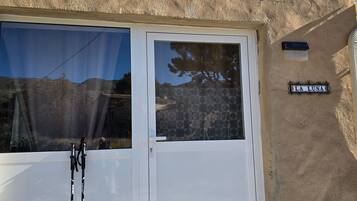 Un edificio con una puerta blanca y una ventana, un letrero que dice 'LA LUNA', y un par de zapatos en el suelo.