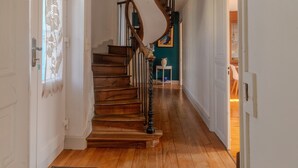 Un escalier en bois avec une rampe incurvée, des murs blancs et un mur d’accent bleu en arrière-plan.