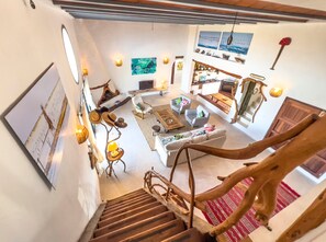 A spacious living area with a staircase, a kitchen, and a dining area. - Holiday Home 'Can Picca' with Sea Views, Private Pool and Wi-Fi (Illes Balears)