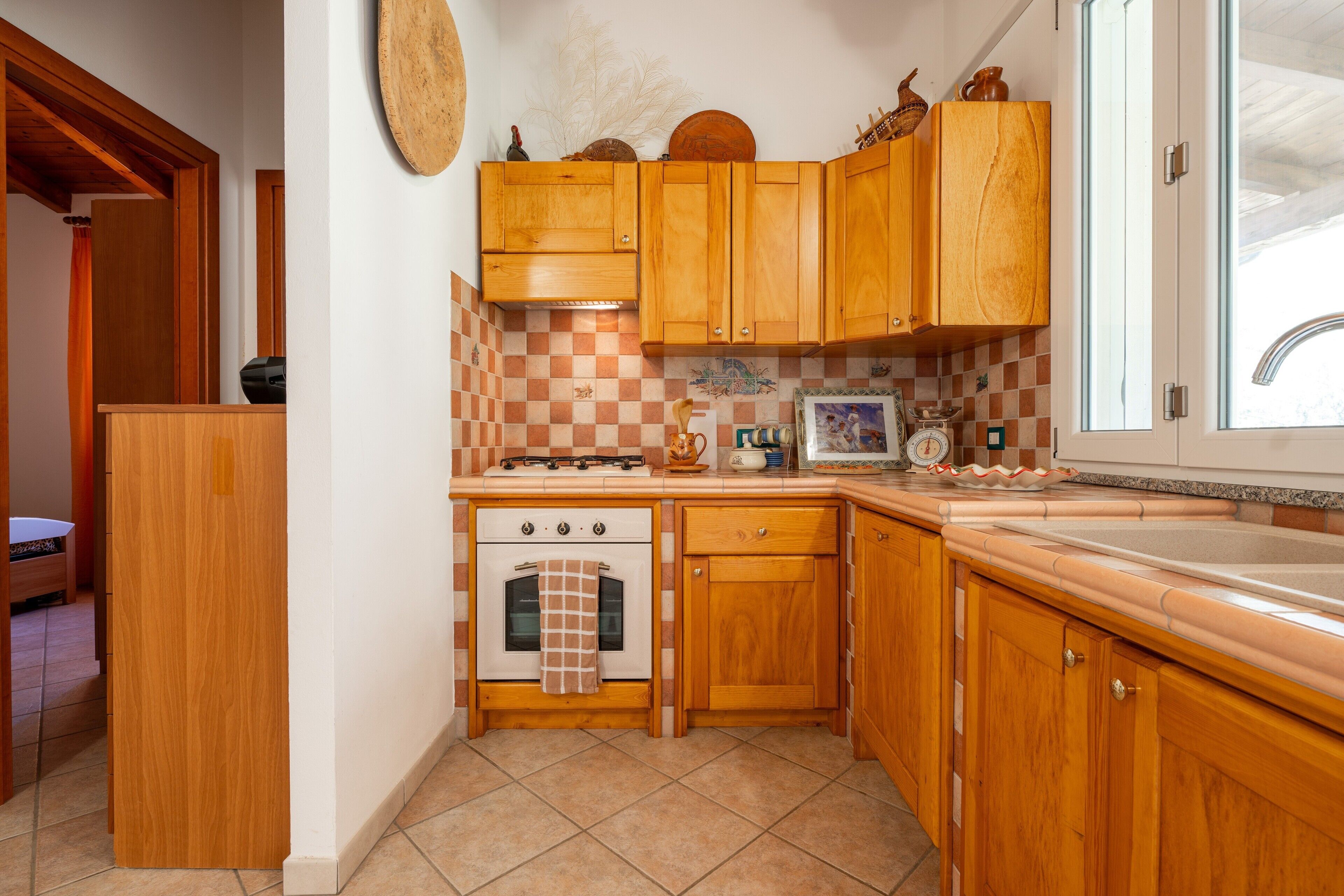 A kitchen with wooden cabinets, a stove, and a sink.