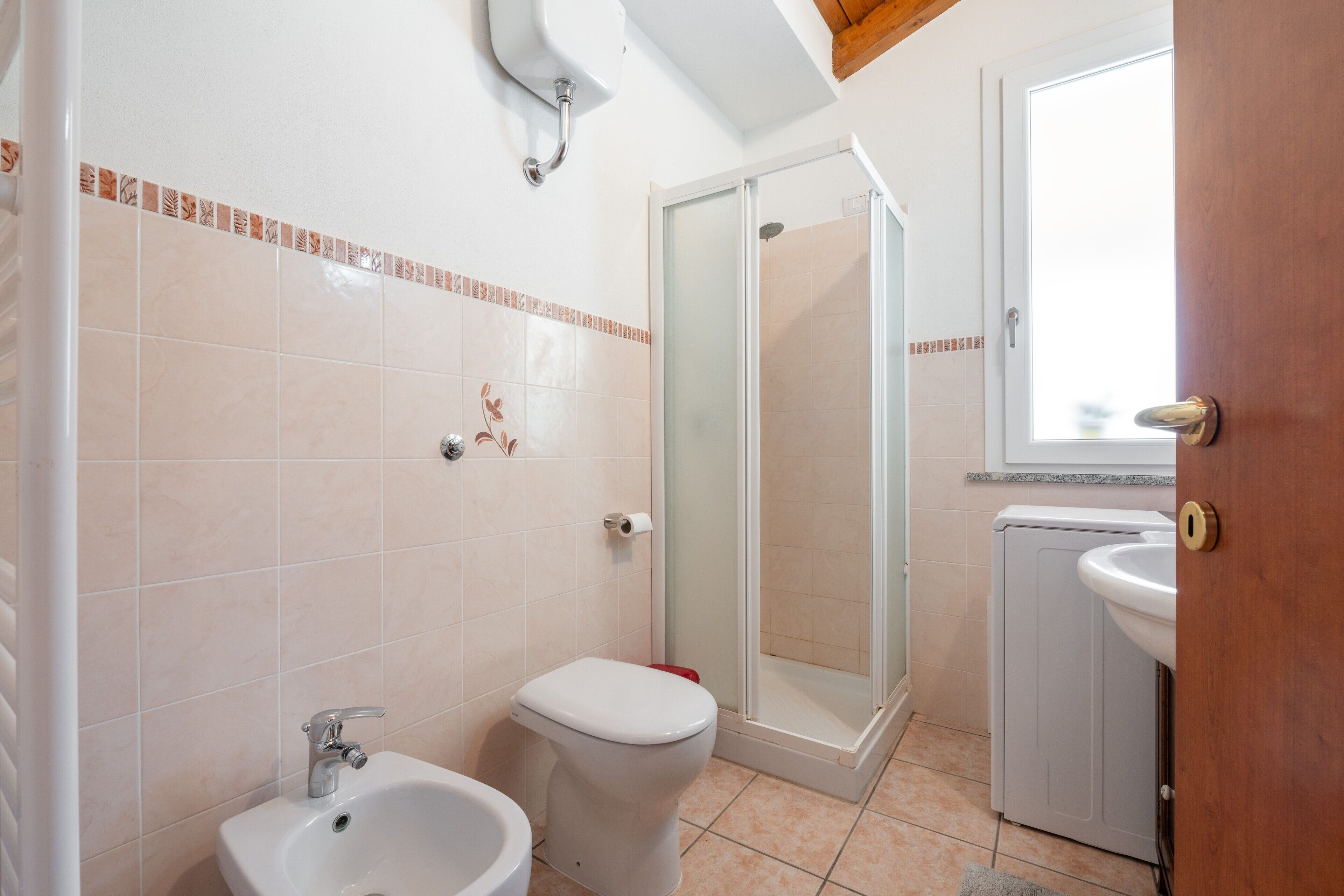 Une salle de bain équipée d’une douche, de toilettes, d’un bidet et d’un lavabo.