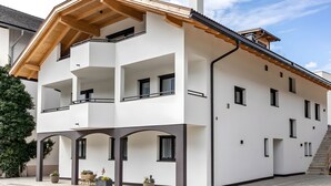 Un edificio de varios pisos con balcones, techo de madera y una escalera.