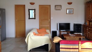 Une chambre avec un lit, une télévision, une petite table et des armoires en bois.