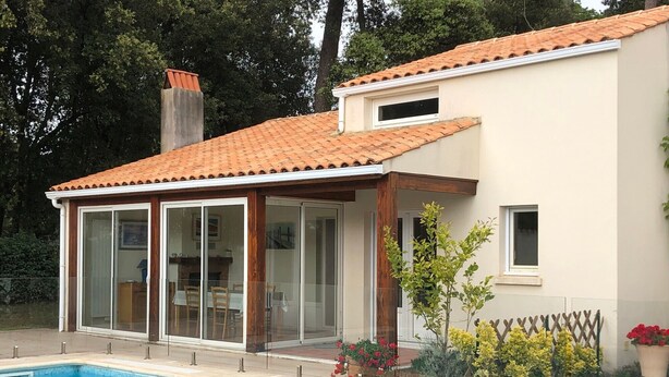 A house with a swimming pool, a covered patio, and a garden with flowers. - Holiday Home with Shared Pool, Private Terrace and Shared Garden (Saint-Trojan-les-Bains)