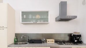 Una cucina moderna con lavello in acciaio inossidabile, piano cottura a gas, forno integrato e microonde.