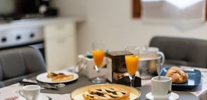 A breakfast table with a coffee cup, a glass of orange juice, a pastry, and a croissant. - LIBERA HOUSE Sweet apartments (San Salvo)
