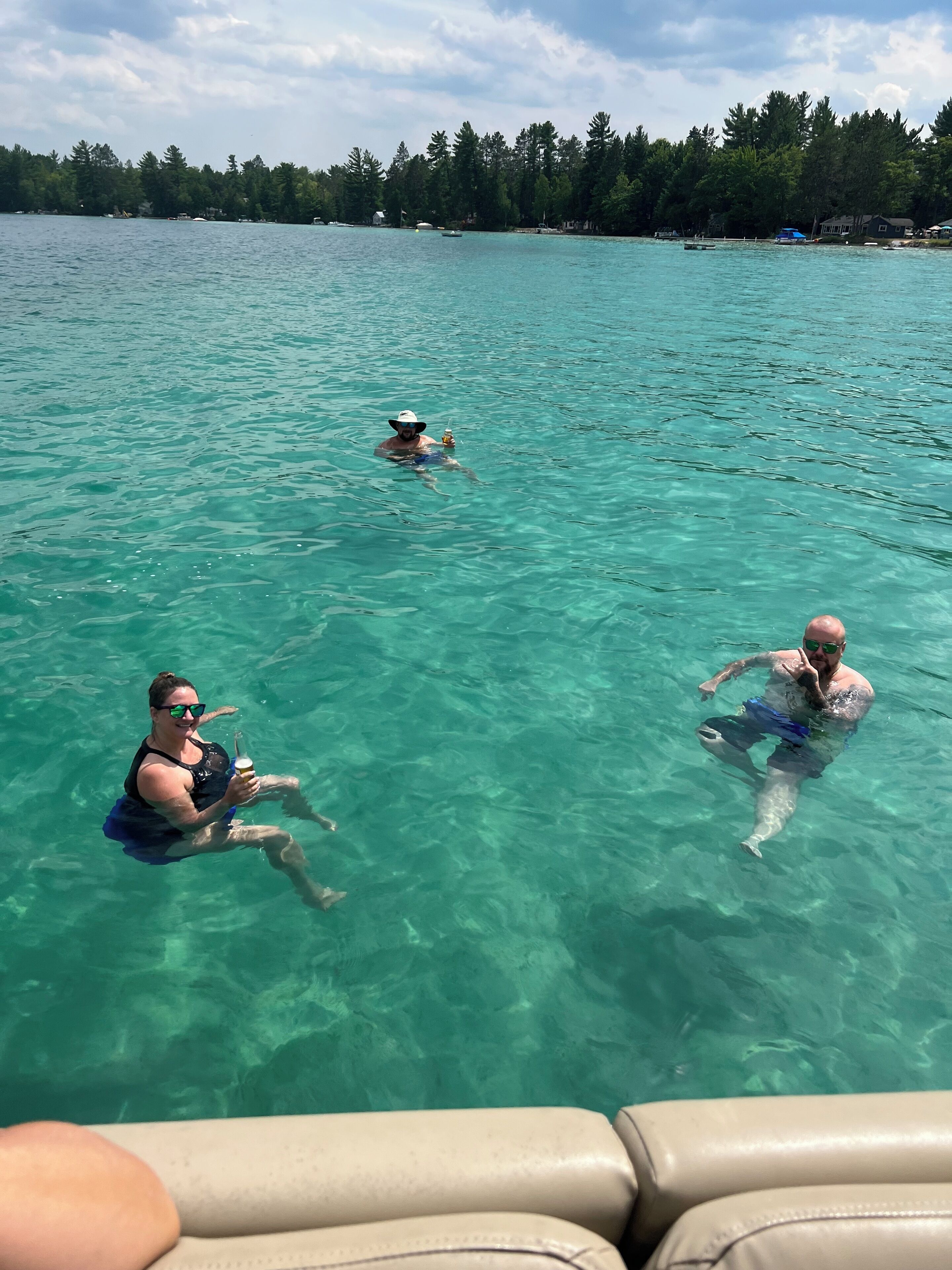 Helder turquoise water met drie mensen die zwemmen.