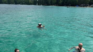 Helder turquoise water met drie mensen die zwemmen.