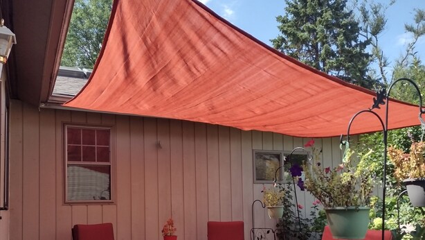A covered patio area with two red chairs, a small table, and a potted plant. - TRAVELERS! In the heart of Baraboo, close to SSM Hospital! (Baraboo)