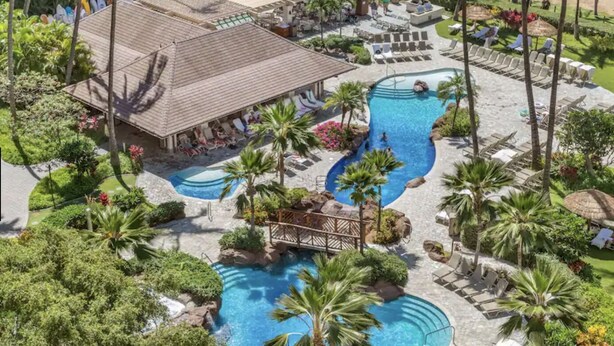 A resort with multiple swimming pools, palm trees, and lounge areas.