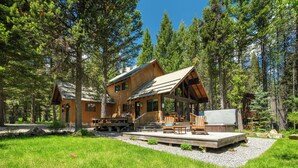 Eine Blockhütte mit Veranda, Sitzgelegenheiten im Freien und einer Terrasse.