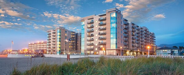 A multi-story hotel with balconies, located near a waterfront. - Seaside!! Condo with ocean view, grill on balcony, beach access from the resort. (Seaside)