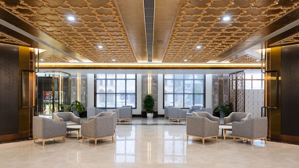A spacious lobby with a polished floor, modern seating, large windows, and a decorative ceiling. - Grand Pailin Casino & Resort (Sala Krau)