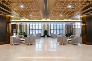 A spacious lobby with a polished floor, modern seating, large windows, and a decorative ceiling. - Grand Pailin Casino & Resort (Sala Krau)
