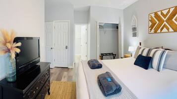 A hotel room with a bed, a TV, a dresser, and a wardrobe.
