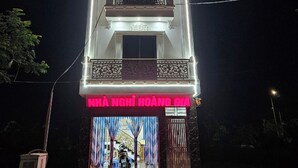 A multi-story building with a prominent neon sign reading "HOANG GIA HOTEL" at the top. - Hoàng Gia Hotel Royal (Le Ho)