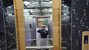 An elevator with a marble floor and a framed painting on the wall. - Hoàng Gia Hotel Royal (Le Ho)