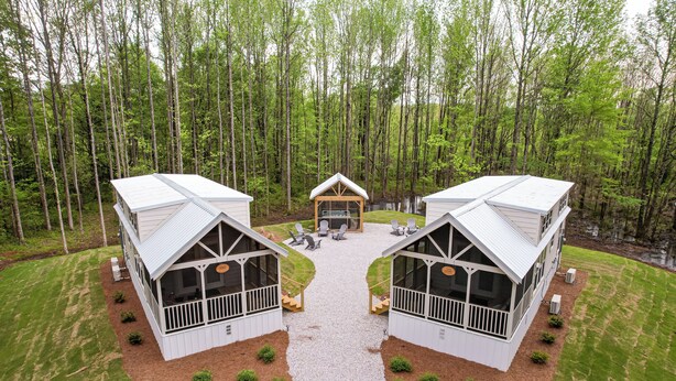 A cabin-style building with a central open area, surrounded by a forest.