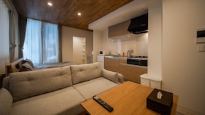 Sala de estar moderna com sofá, mesa de madeira e controle remoto.