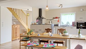 Une cuisine spacieuse avec une table à manger en bois, des bancs et divers appareils de cuisine.