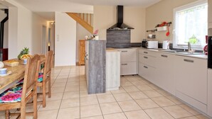 Une cuisine moderne avec un îlot central, des chaises en bois et une table à manger.