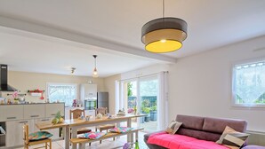Une cuisine moderne avec un coin repas, un canapé et une table avec des verres à vin.