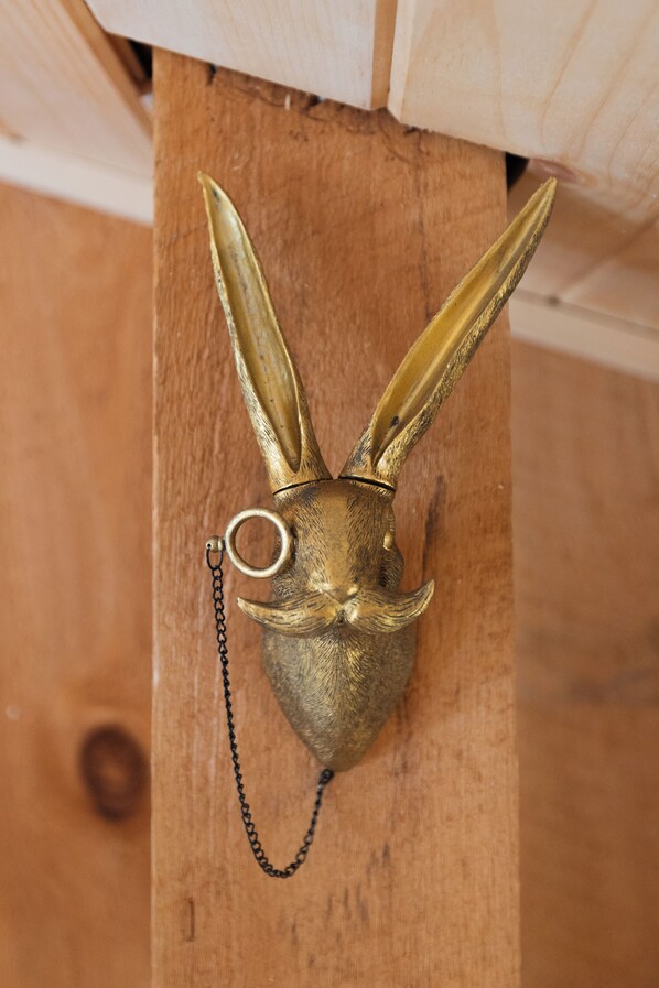 A brass animal head mounted on a wooden post.