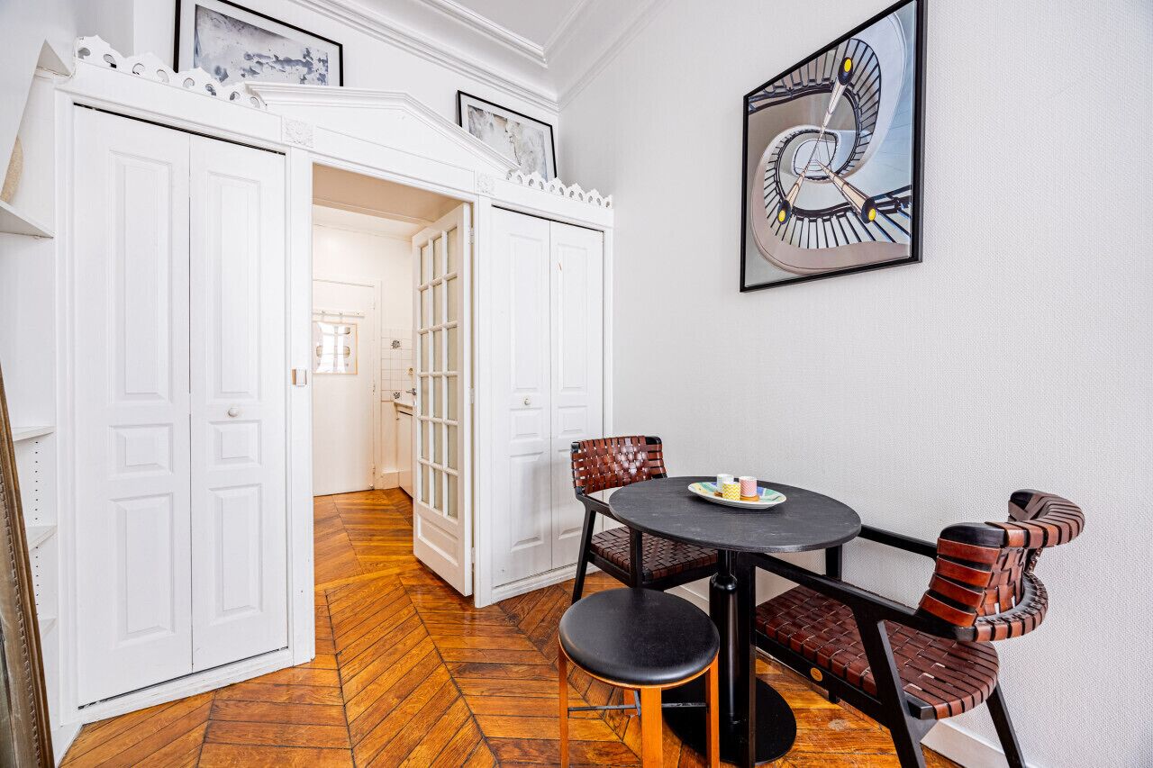 A dining area with a round table, two chairs, and a bench.