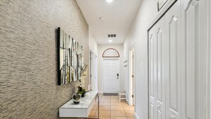 A hallway with a textured wall, a white door, and a white cabinet. - 5BD Paradise Palms Resort Near Parks (PP 8976) (Kissimmee)