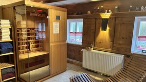 A cozy room with a wooden bench, a glass cabinet with towels, and a radiator. - Vacation home Selma by Interhome (Grossschönau)