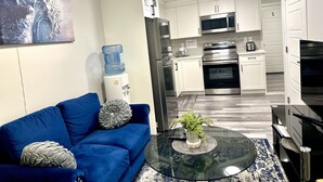 A modern kitchen with white cabinets, stainless steel appliances, and a water dispenser. - Global Family Canada (Calgary)