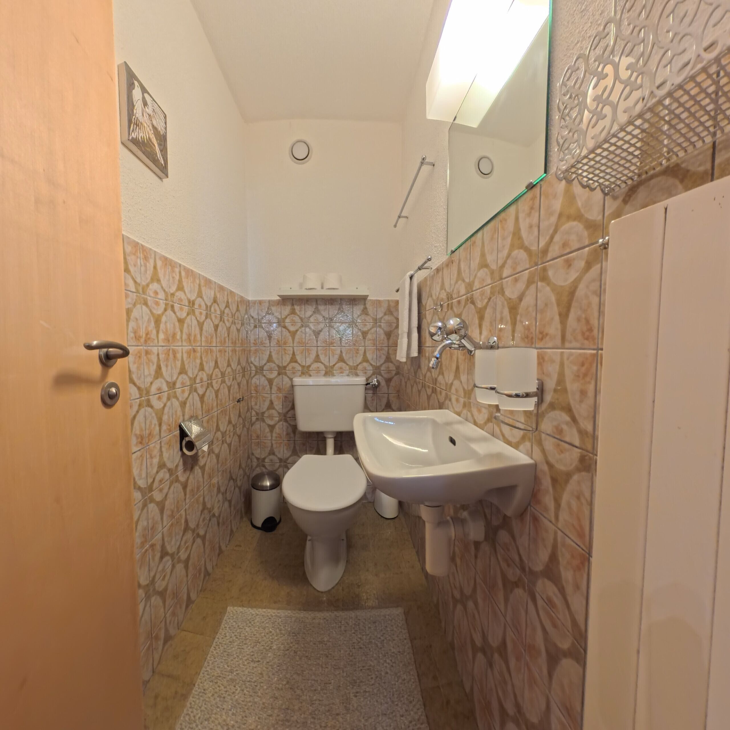 Ein Badezimmer mit Toilette, Bidet, Waschbecken und Spiegel.