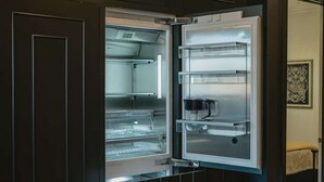 An open refrigerator with multiple shelves and a microwave. - Perfect for Couples-Walk Everywhere-Luxe Apt (Rogers)